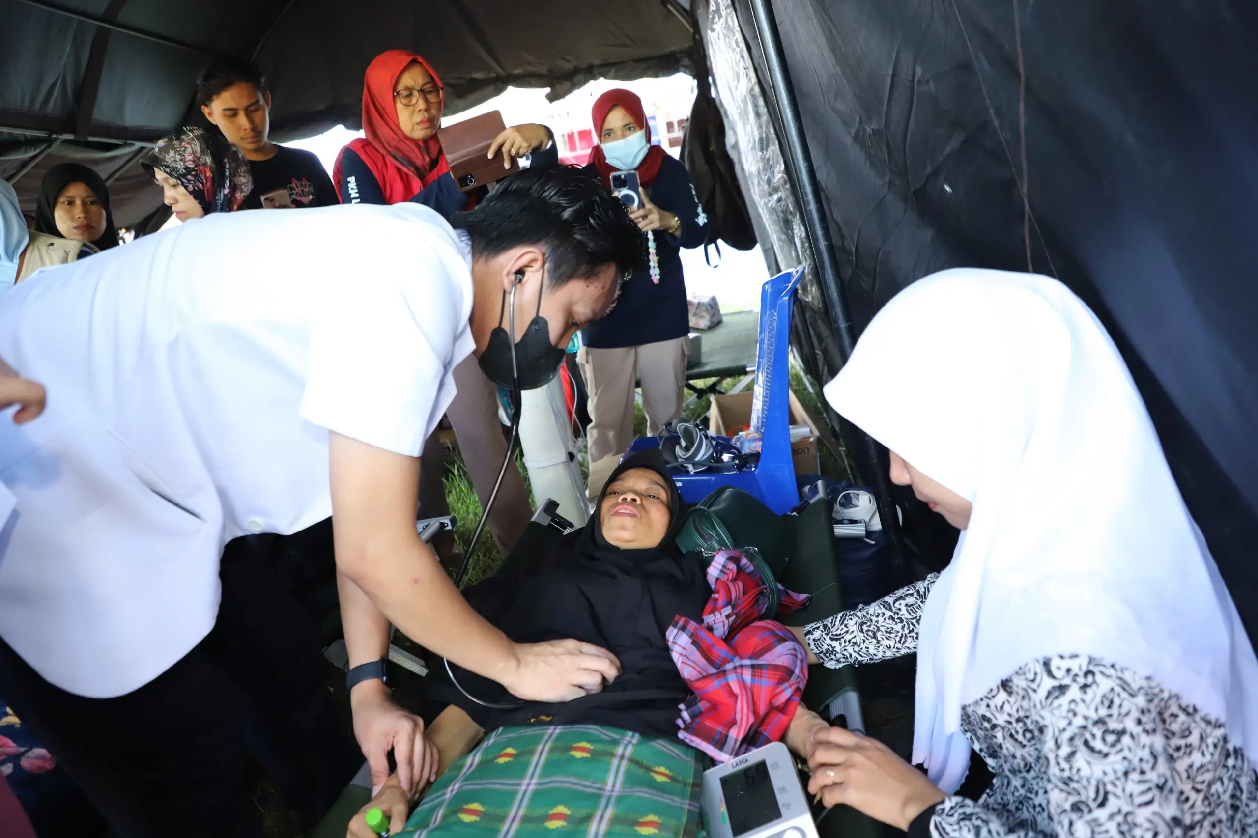 Tenaga kesehatan memeriksa warga yang sakit di Pos Kesehatan, Pos Komando Utama Tanggap Darurat Banjir dan Tanah Longsor Kabupaten Luwu Sulawesi Selatan, Rabu (8/5).